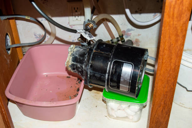 An old, corroded garbage disposal unit removed from under a sink