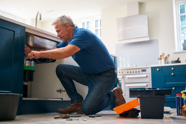 Technician repairing a garbage disposal under a kitchen sink in Amarillo, TX